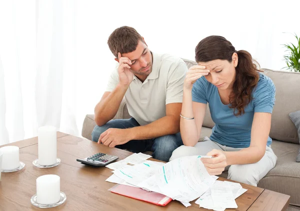 Worried couple doing their accounts in the living room — Stock Photo, Image