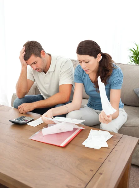 Worried couple looking at their bills in the living room — Stock Photo, Image