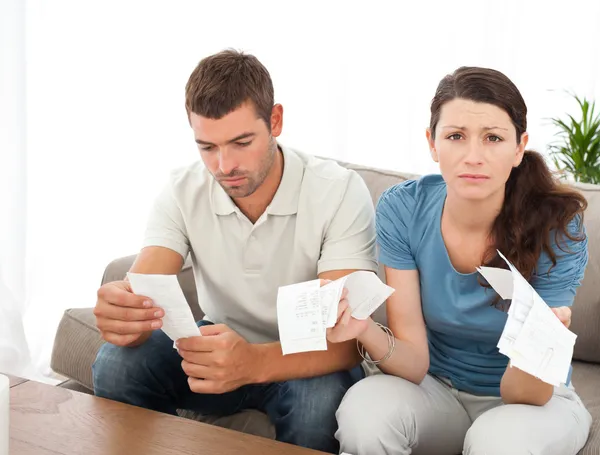 Отчаянная женщина ведет счета со своим парнем, сидящим на — стоковое фото