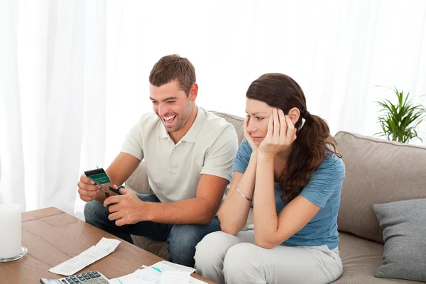 Happy man cutting his credit card with scissors with his girlfri — Stock Photo, Image