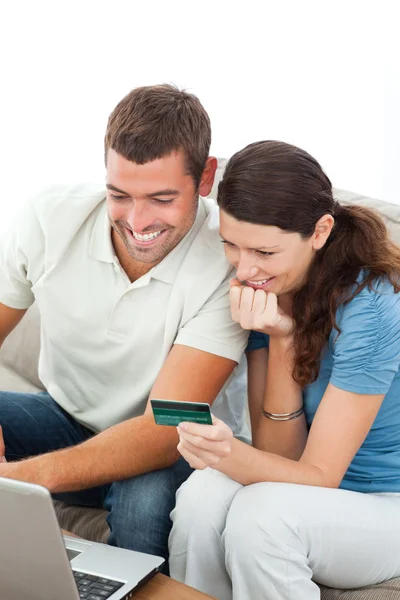 Прекрасная пара покупает онлайн с помощью ноутбука и кредитной карты — стоковое фото