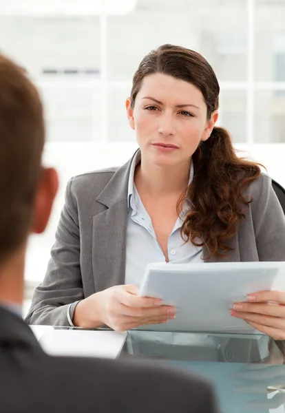 Серьёзная деловая женщина опрашивает мужчину во время встречи — стоковое фото