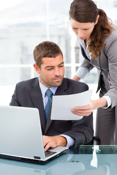 Two business looking at a paper while working on the lapt — Stock Photo, Image