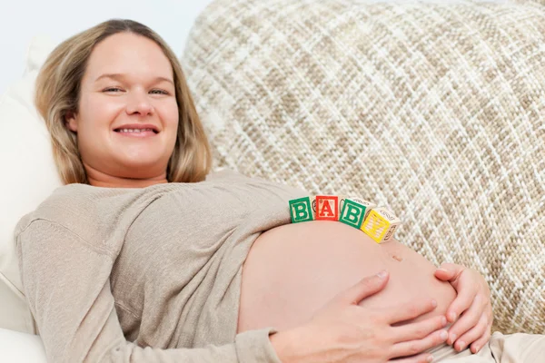 Bela futura mãe com letras de bebê na barriga — Fotografia de Stock