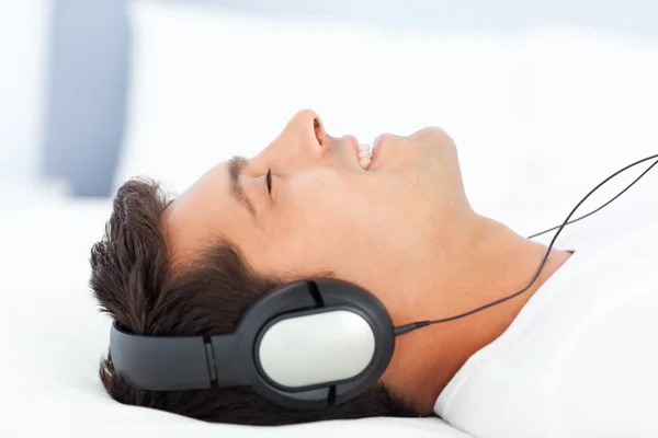 평화로운 사람이 듣는 음악으로 편안한 그의 침대에 — 스톡 사진