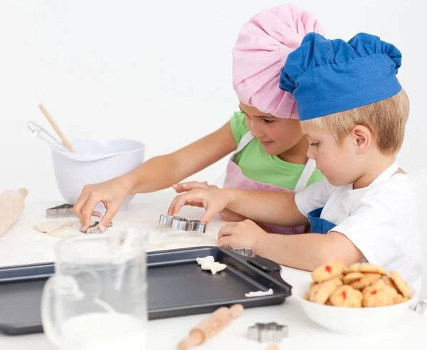 Słodkie rodzeństwo pieczenia ciasteczka razem w kuchni — Zdjęcie stockowe
