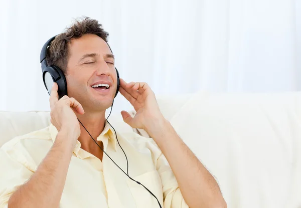 Spokojny człowiek słuchania muzyki na kanapie — Zdjęcie stockowe