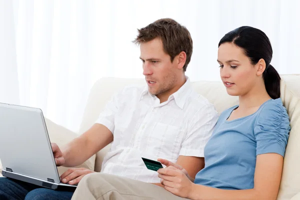 Vacker kvinna läser koden på ett kreditkort för hans pojkvän — Stockfoto