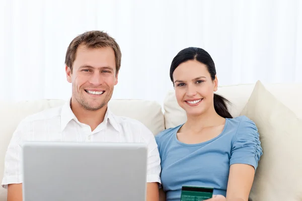Couple détendu avec ordinateur portable et carte de crédit assis sur le canapé — Photo