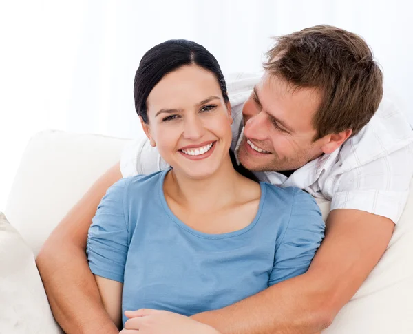 Hombre apasionado abrazando a su novia mientras se relaja en el sofá —  Fotos de Stock