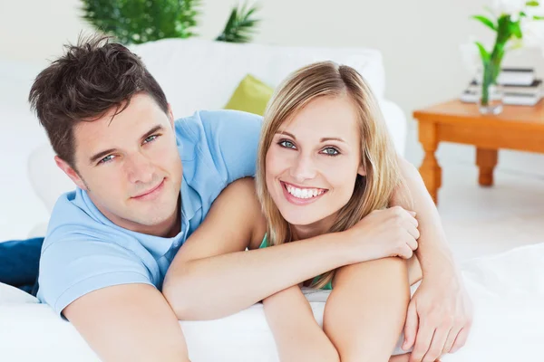 Smiling beatiful couple sitting on a sofa Stock Picture