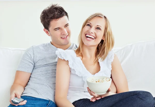 Portrait of a cheerful couple watching a movie with popcorn sit — Stock Photo, Image