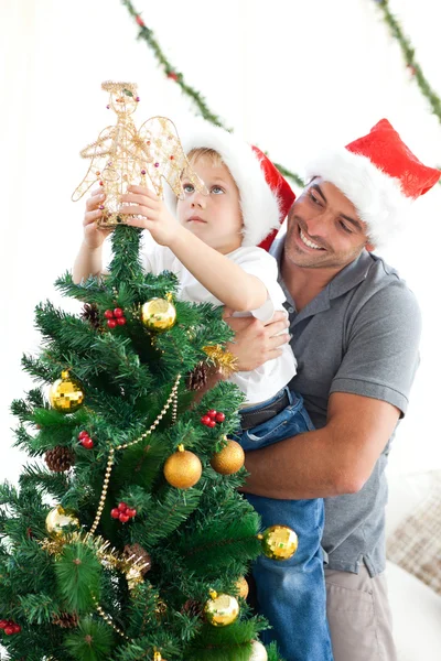 Vader en zoon versieren hun kerstboom Stockfoto