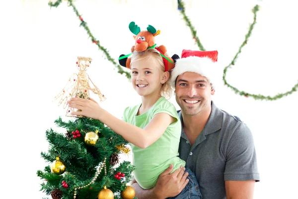 Mutlu baba ve kız Noel ağacını süslüyorlar. Stok Fotoğraf