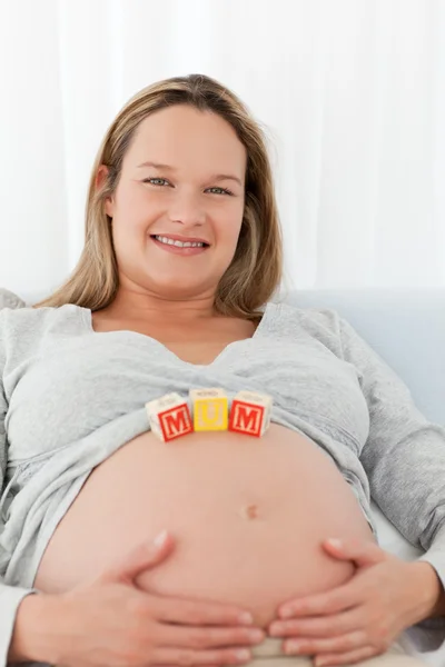 Adorable future mother with mom letters on her belly Royalty Free Stock Photos