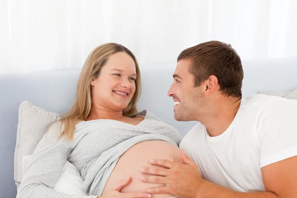Lovely future parents resting on a bed Royalty Free Stock Photos