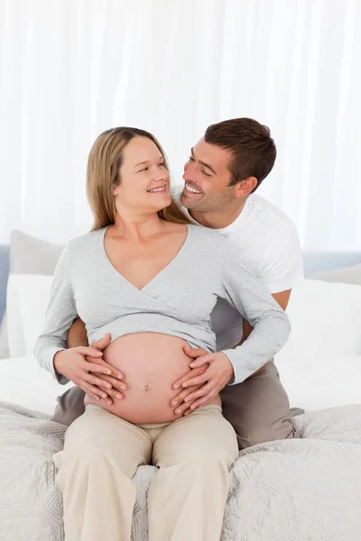 Cute future parents looking at each other while feeling their ba Royalty Free Stock Photos