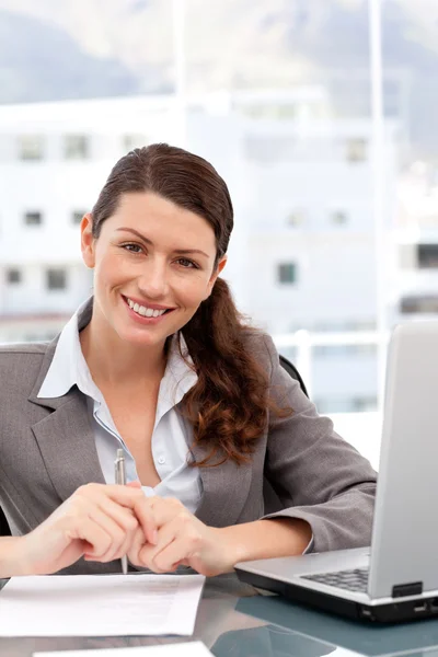 Pretty woman on the computer smiling at the camera Royalty Free Stock Images