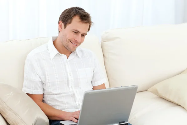 Cute man surfing on the web on the sofa — Stock Photo, Image