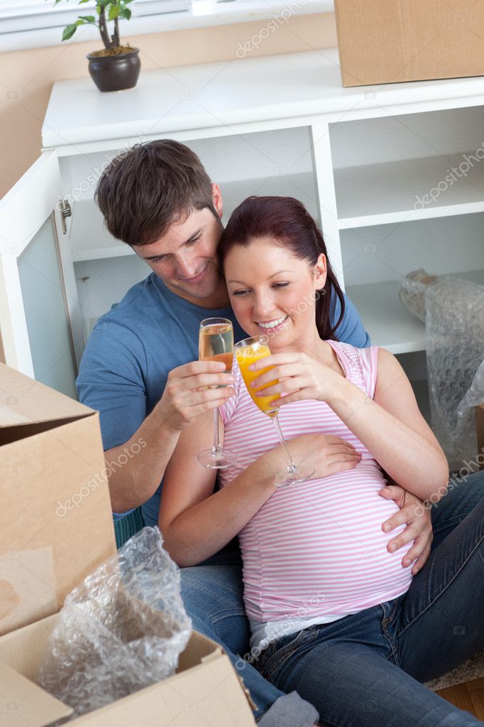 Cheerful couple celebrating pregnancy and removal with champagne Stock