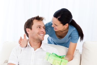 Happy man receiving a present from his girlfriend clipart