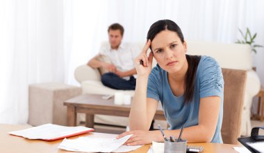 Worried woman doing her account while her boyfriend waiting in t clipart