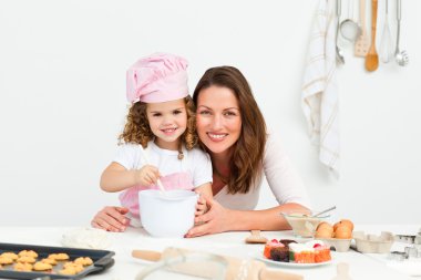 Portrait of an adorable mother and daughter preparing a daugh to clipart
