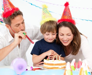 Happy family blowing candles together for a birthday clipart