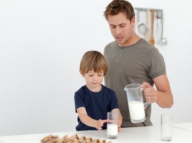 Handsome man giving milk to his son clipart