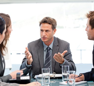Severe manager talking to his team at a table clipart
