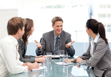 Cheeful manager talking to his team at a meeting clipart
