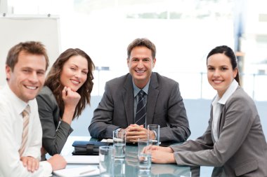 Portrait of a positive team sitting at a table clipart