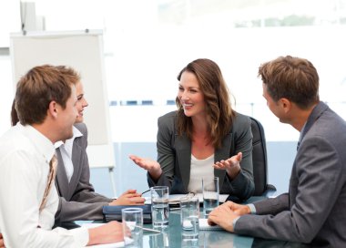 Attractive businesswoman laughing with her team clipart