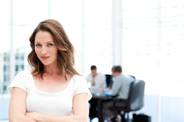 Beautiful businesswoman standing in front of her team while work clipart