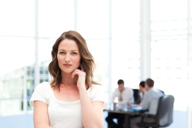 Pensive businesswoman standing in front of her team while workin clipart