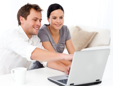 Cute man showing something on the laptop screen to his girlfrien clipart