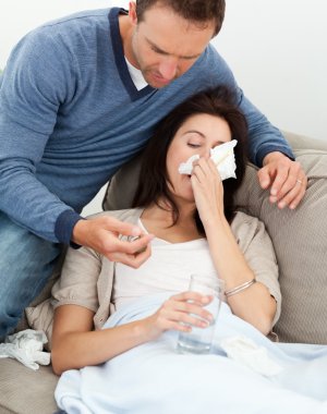 Handsome man taking care of his sick girlfriend clipart