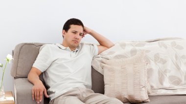 Depressed man thinking on the sofa clipart