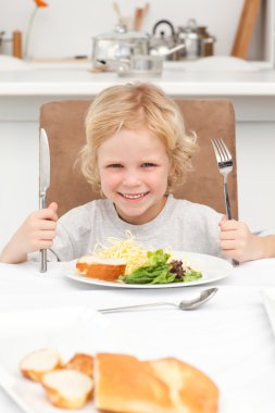 Portrait of a little boy ready to eat pasta and salad clipart