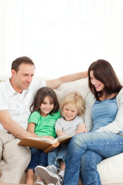 Cheerful family looking at a photo album together clipart