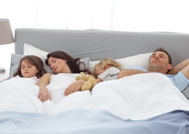 Tranquil children sleeping with their parents clipart