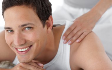 Portrait of a happy man receiving a massage from his girlfriend clipart