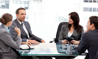 Charismatic businessman talking to his partners during a meeting clipart