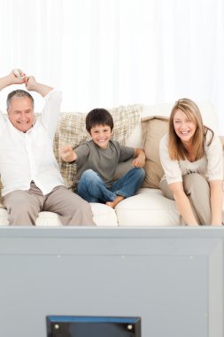 A little boy with his grandparents in the living room clipart