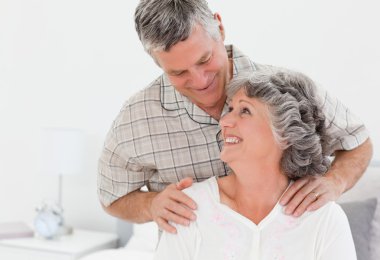 Retired man giving a massage to his wife clipart