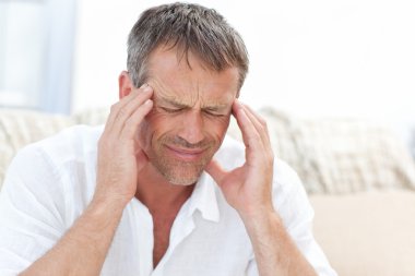 Man having a headache at home clipart