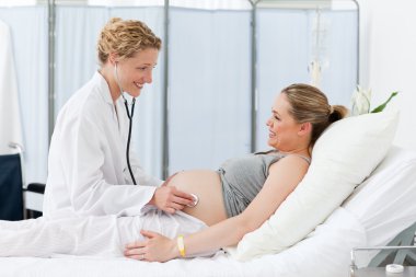 Nurse reassuring her pregnant patient clipart