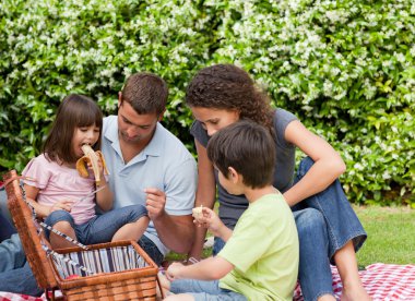 Family picnicking in the garden clipart