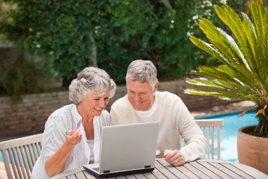 Retired couple buying something on internet clipart