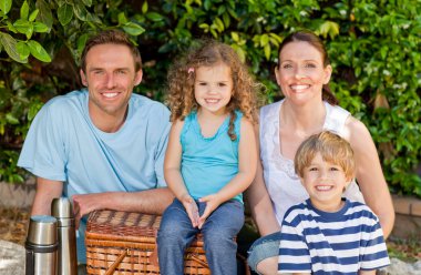 Happy family picnicking in the garden clipart